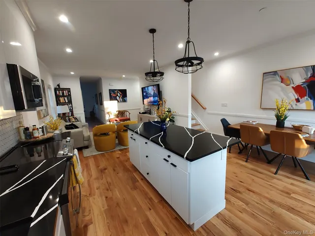 a living room with furniture a flat screen tv and a wooden floor