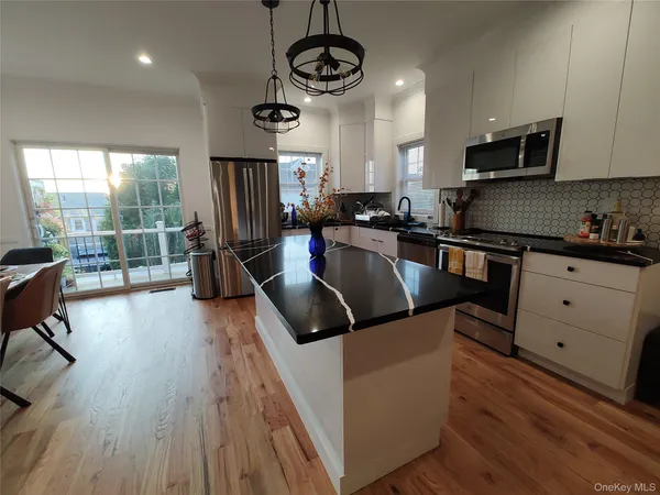 a kitchen with stainless steel appliances granite countertop a sink a stove top oven a counter space and cabinets