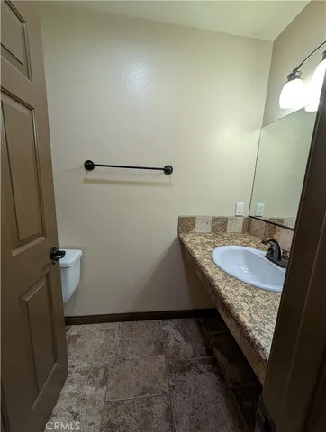 a large kitchen with kitchen island granite countertop a sink and a stove top oven