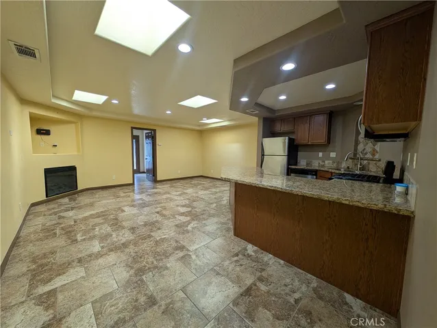 a kitchen with stainless steel appliances granite countertop a refrigerator stove top oven and sink