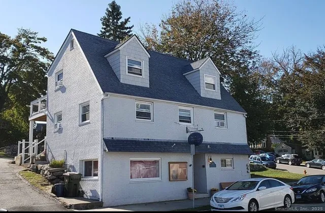 a car parked in front of a white house