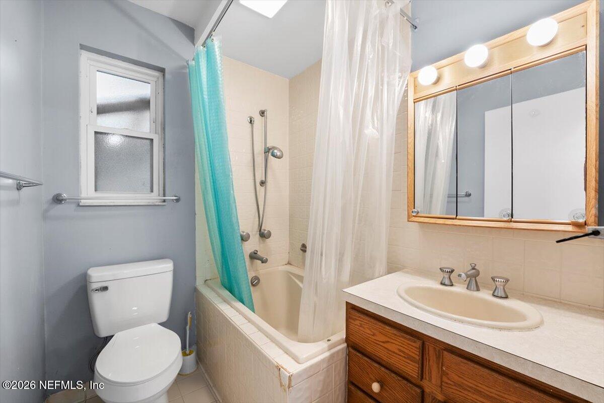 5376 Sanders Road Jacksonville, FL 32277 - Photo 21 of 44 a bathroom with a toilet a sink and a mirror