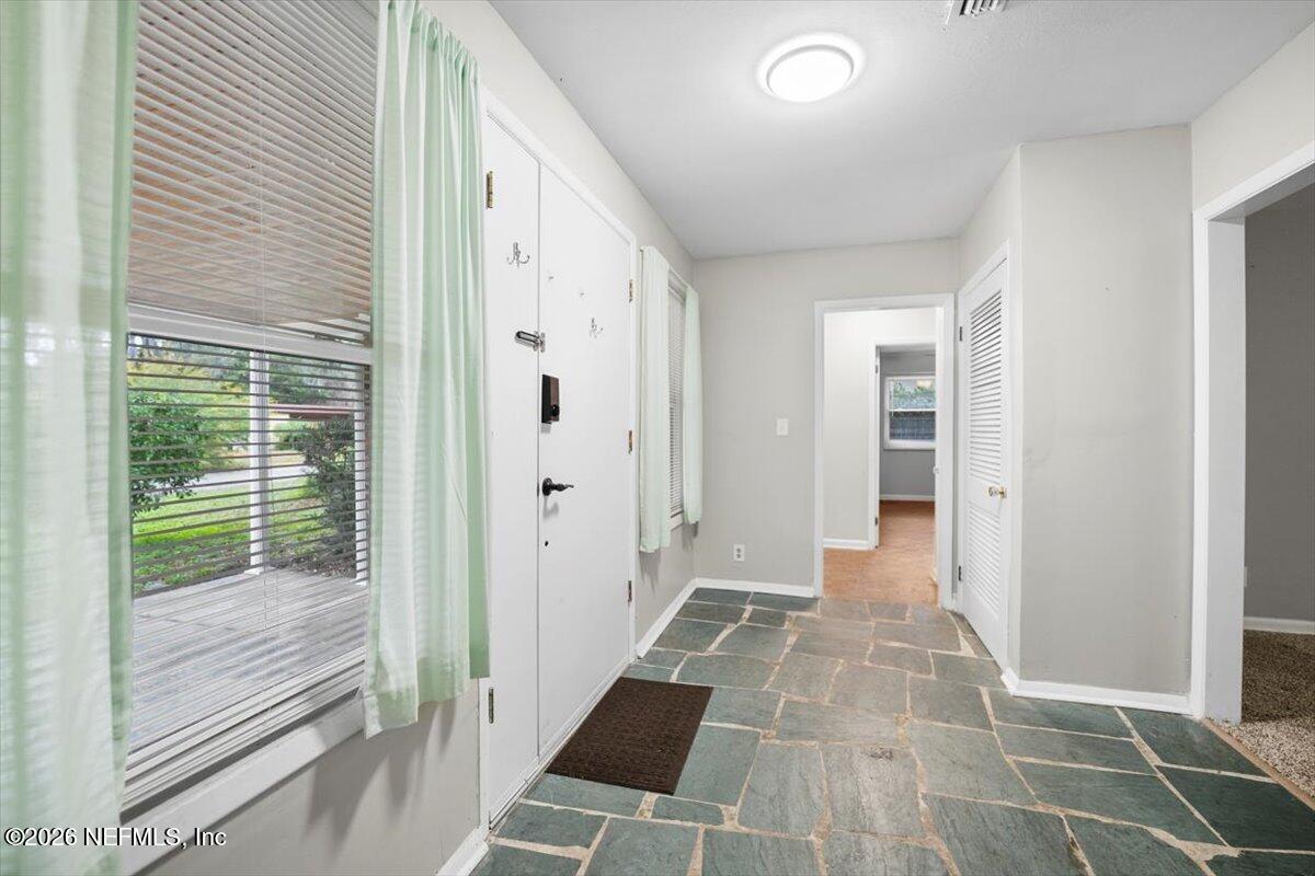 5376 Sanders Road Jacksonville, FL 32277 - Photo 5 of 44 a view of a hallway with wooden floor and windows