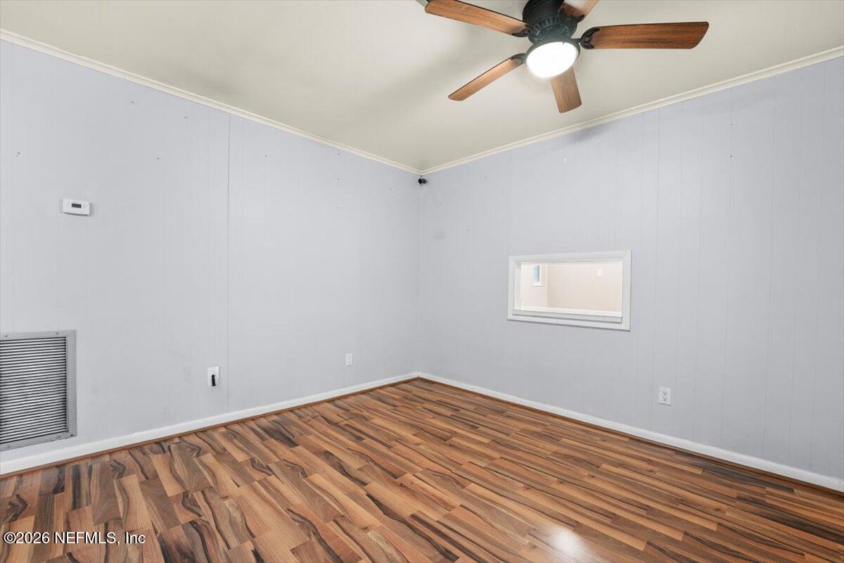 5376 Sanders Road Jacksonville, FL 32277 - Photo 8 of 44 a view of a room with wooden floor and a ceiling fan
