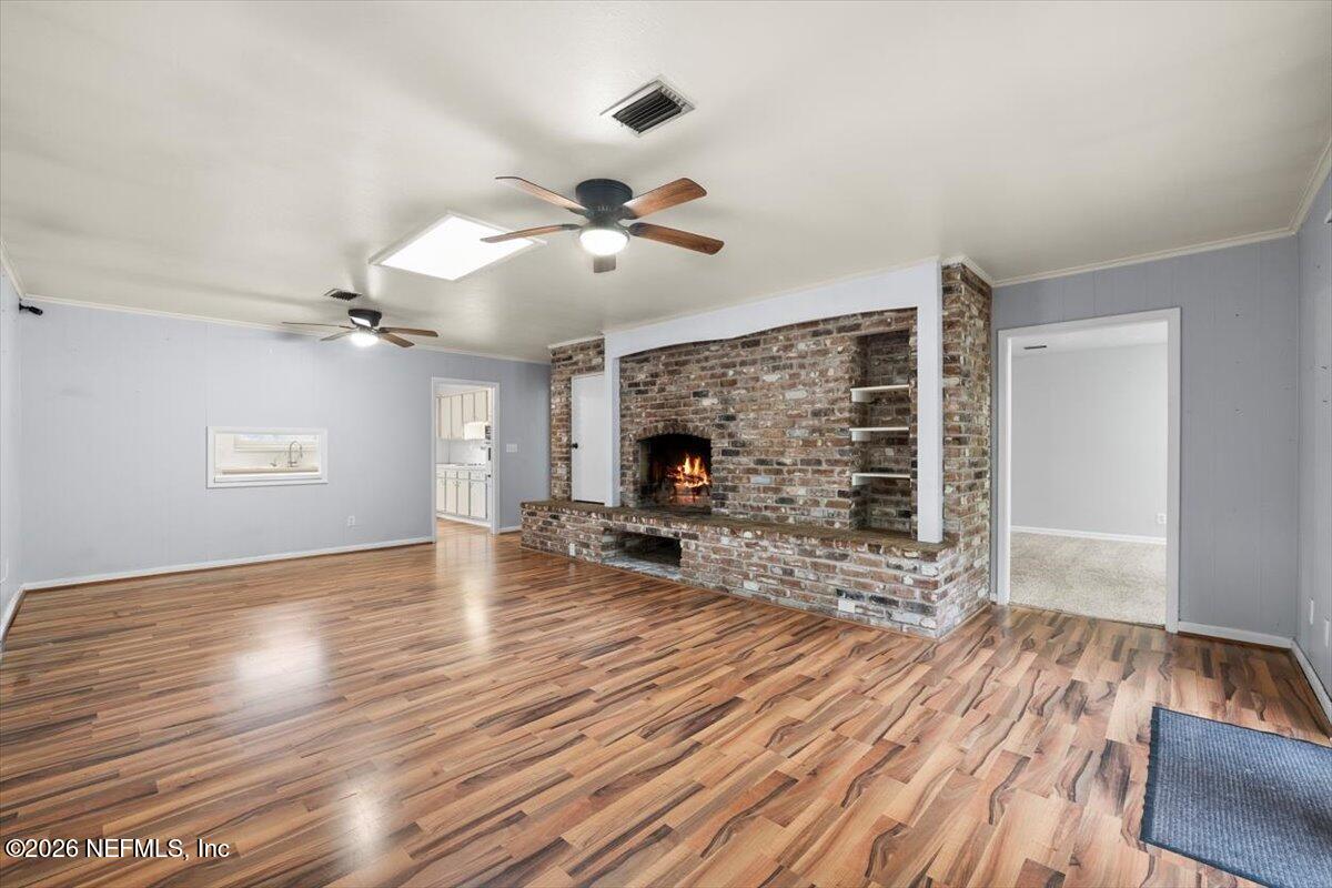 5376 Sanders Road Jacksonville, FL 32277 - Photo 9 of 44 a view of a livingroom with wooden floor and a ceiling fan