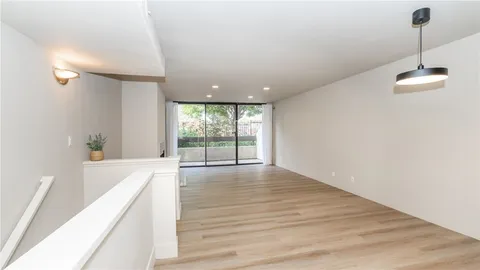 a view of a room with wooden floor and window