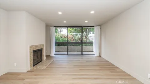 a view of an empty room with a fireplace and a window