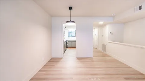 a hallway with wooden floor windows and a chandelier