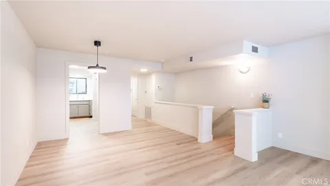a view of a kitchen with furniture and wooden floor
