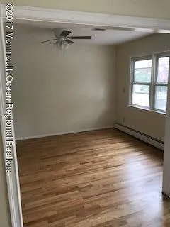 a view of a room with wooden floor and a window