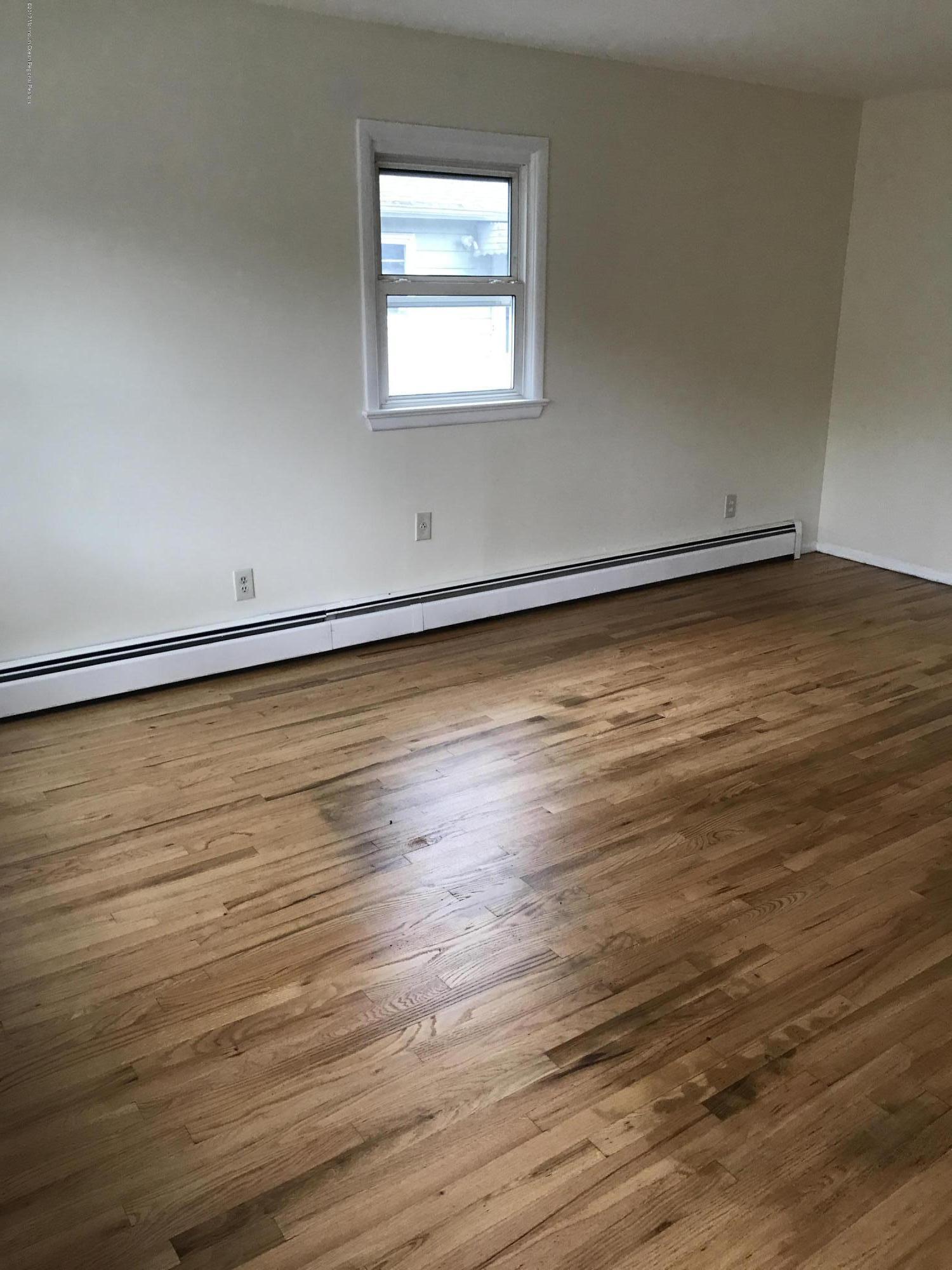 7 Pearl Drive Howell, NJ 07731 - Photo 10 of 13 an empty room with wooden floor and windows