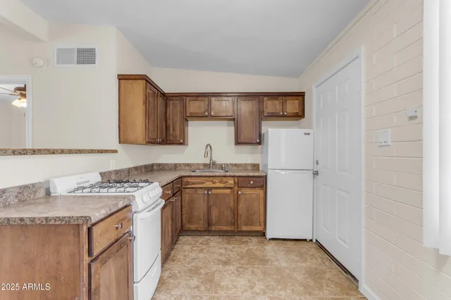 a kitchen with stainless steel appliances granite countertop a sink stove and refrigerator