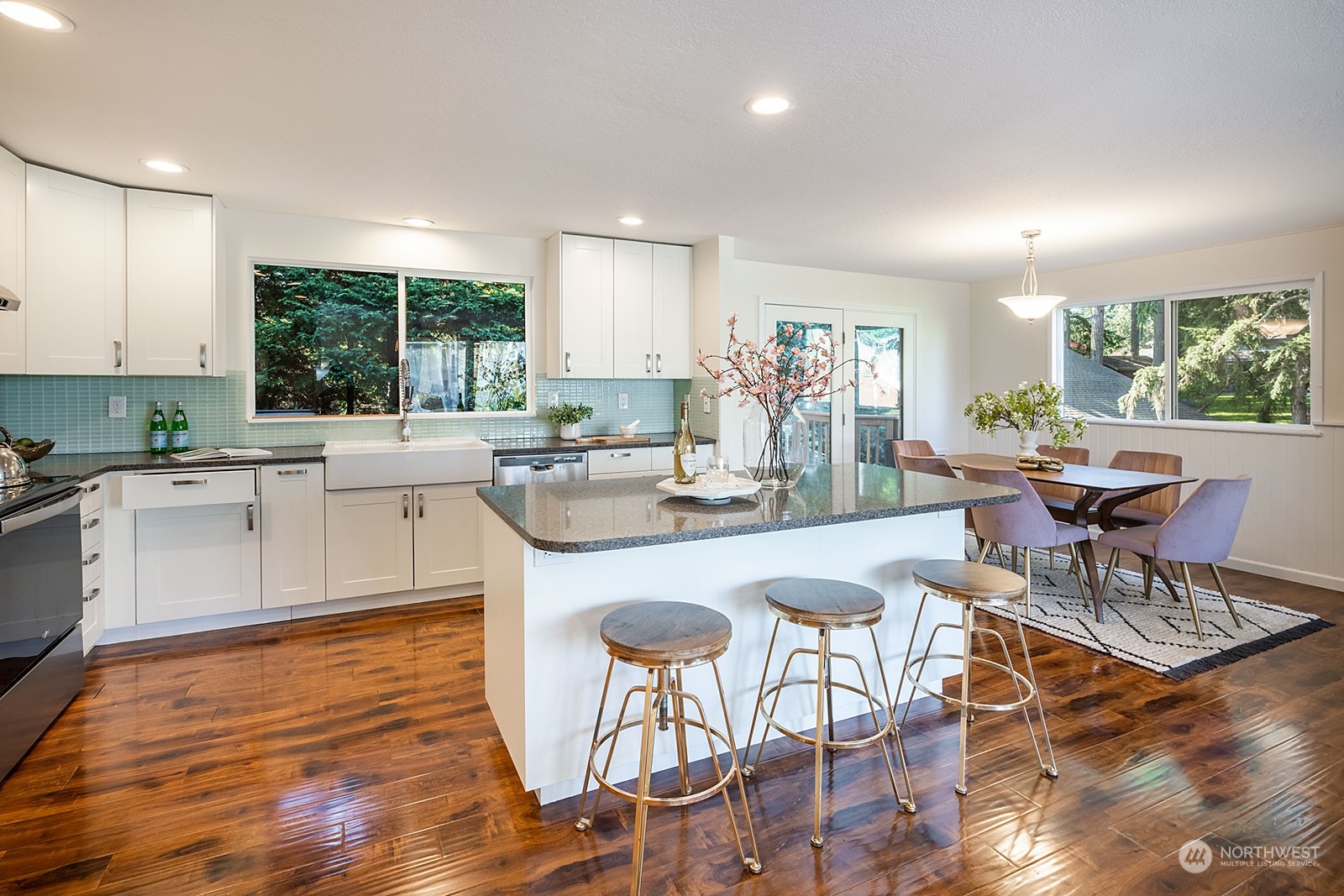 2116 242nd Street Southwest Bothell, WA 98021 - Photo 10 of 38 a large dining hall with stainless steel appliances granite countertop a stove a dining table and chairs with wooden floor