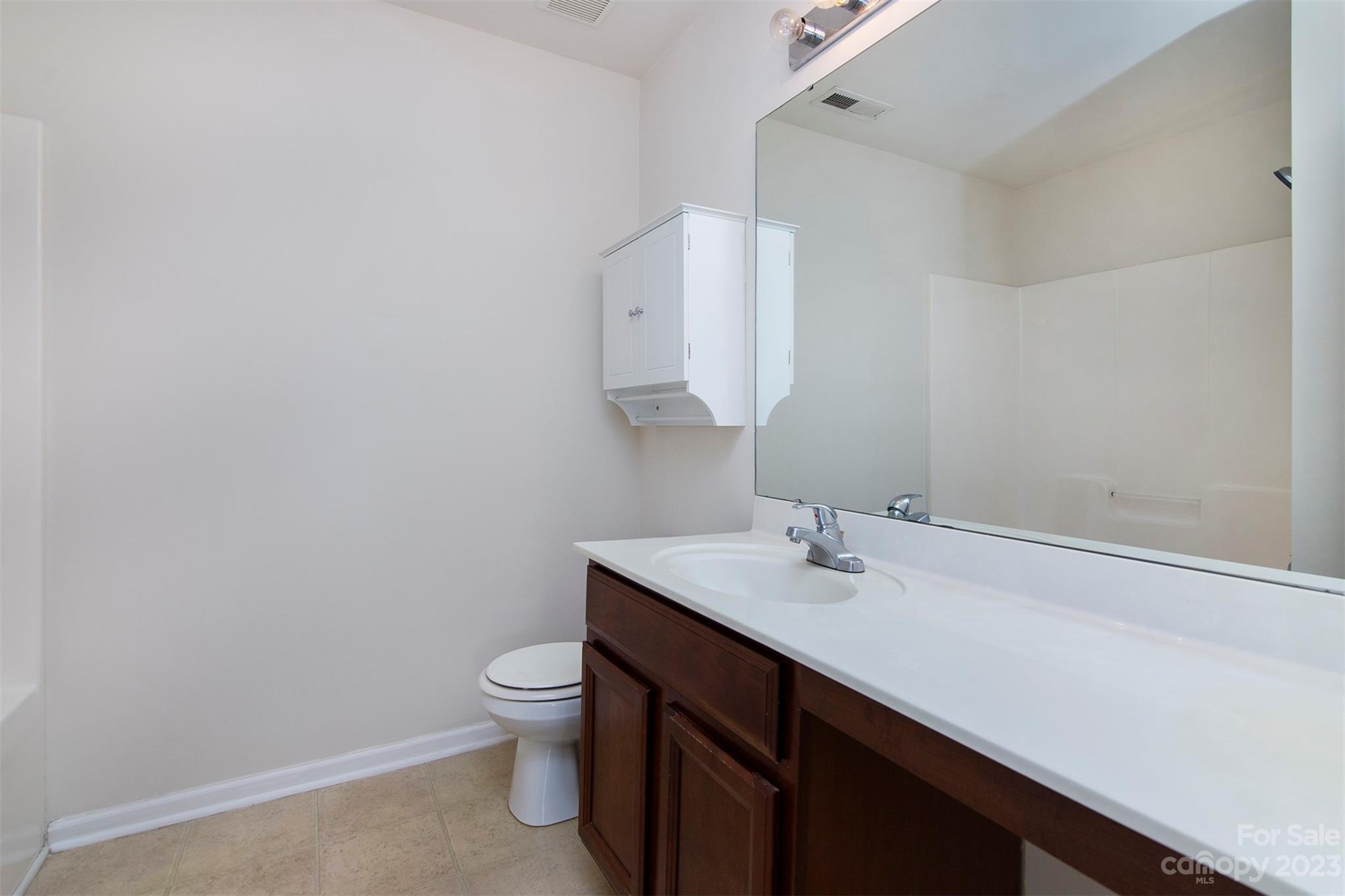 9629 Rothman Lane Charlotte, NC 28215 - Photo 19 of 24 a bathroom with a sink a toilet and a mirror
