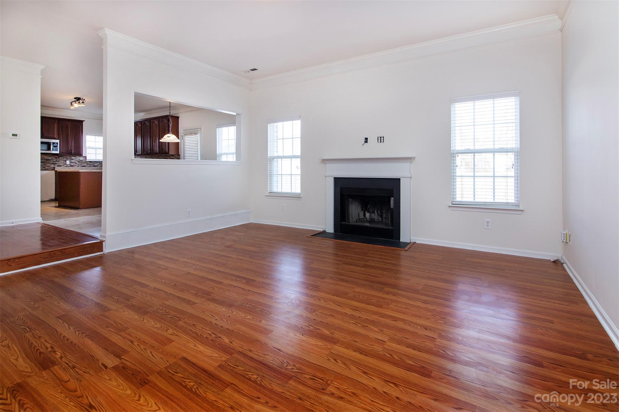 9629 Rothman Lane Charlotte, NC 28215 - Photo 5 of 24 an empty room with wooden floor a fireplace and windows
