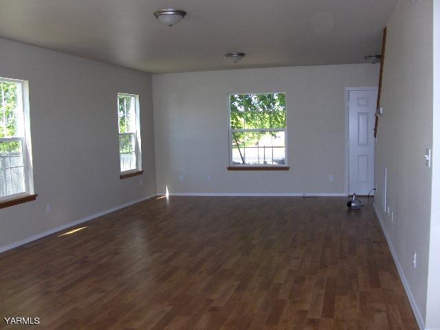 1040 Lombard Loop Road Wapato, WA 98951 - Photo 7 of 25 a view of an empty room with wooden floor and a window