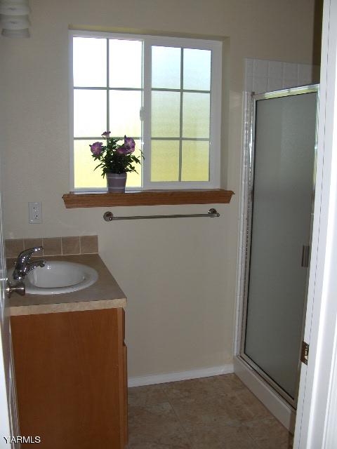 1040 Lombard Loop Road Wapato, WA 98951 - Photo 10 of 25 a bathroom with a sink a window and a mirror