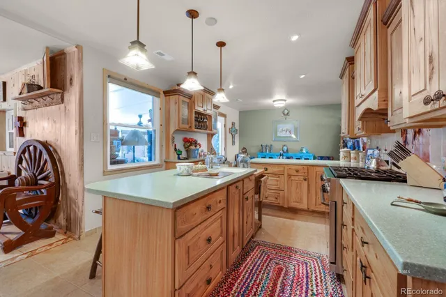 a kitchen with kitchen island granite countertop a stove and a sink