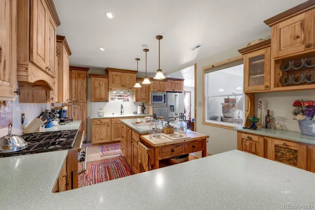 a large kitchen with stainless steel appliances a stove a sink dishwasher and cabinets with wooden floor