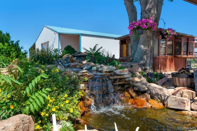 a backyard of a house with table and chairs under an umbrella