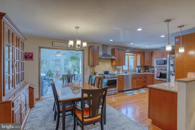 a kitchen with stainless steel appliances granite countertop a refrigerator and a wooden floors
