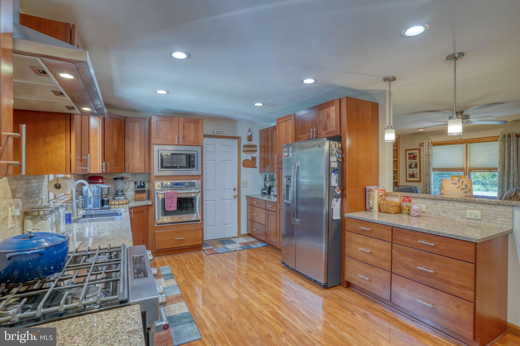 6420 Pearsons Corner Road Dover, DE 19904 - Photo 18 of 54 a kitchen with stainless steel appliances granite countertop a refrigerator and a wooden floors