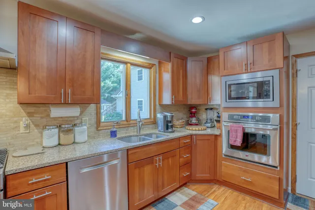 a kitchen with stainless steel appliances granite countertop a refrigerator and a stove top oven