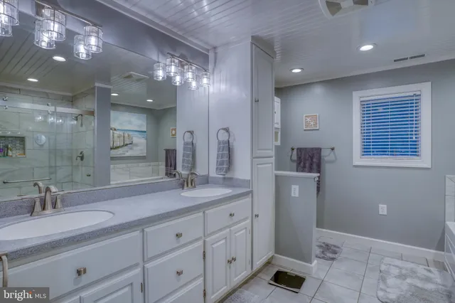 a spacious bedroom with a bed a lamp and window