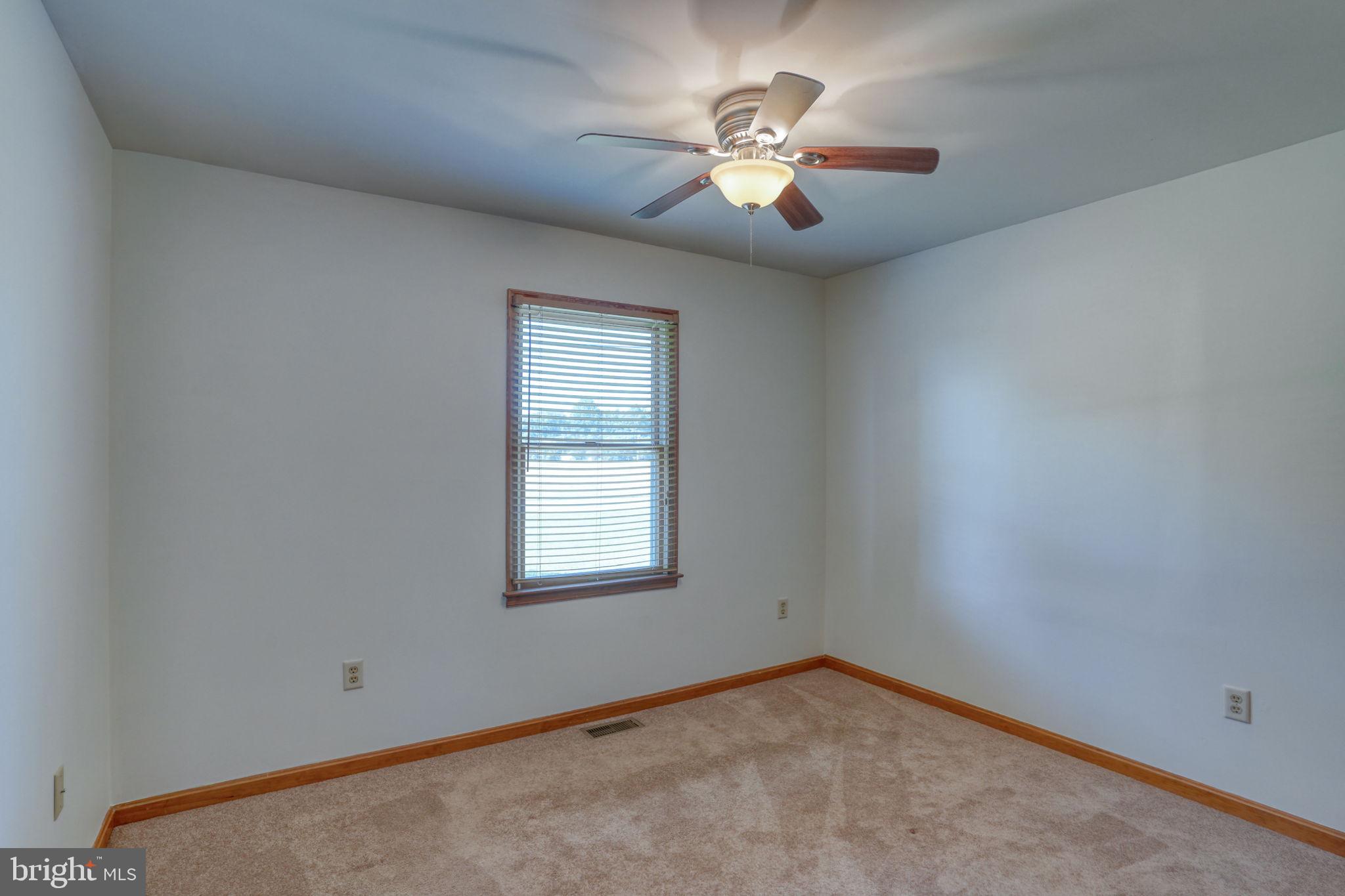 6420 Pearsons Corner Road Dover, DE 19904 - Photo 39 of 54 an empty room with a chandelier fan and windows