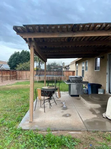 a view of a patio with table and chairs with wooden floor and fence