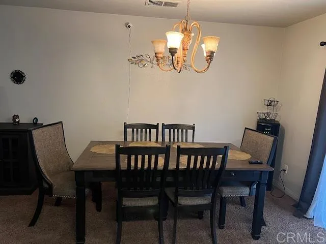 a view of a dining room with furniture and chandelier