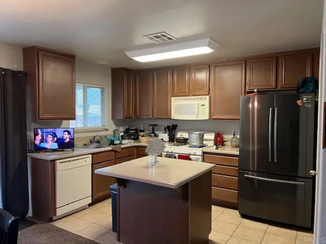 a kitchen with a sink a refrigerator a stove and cabinets