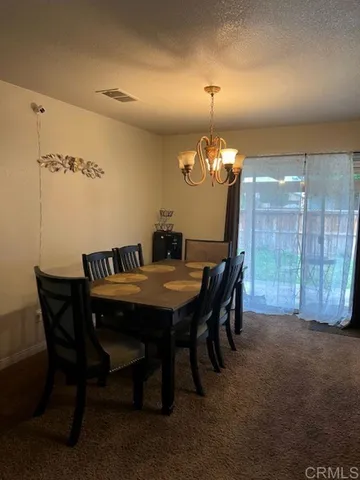 a view of a dining room with furniture and chandelier
