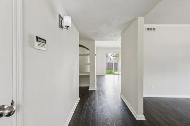 a view of a hallway with wooden floor and staircase