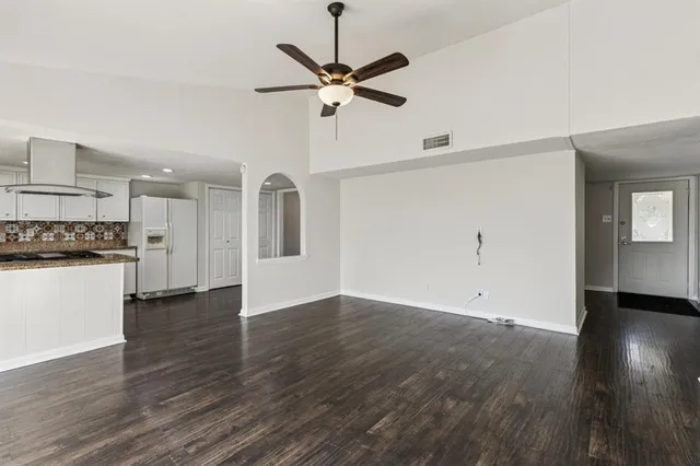 a view of a kitchen with wooden floor and a ceiling fan