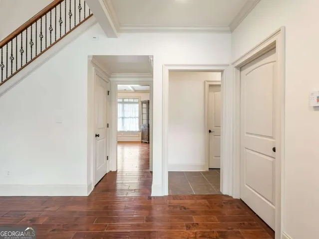 a view of a hallway with wooden floor and staircase