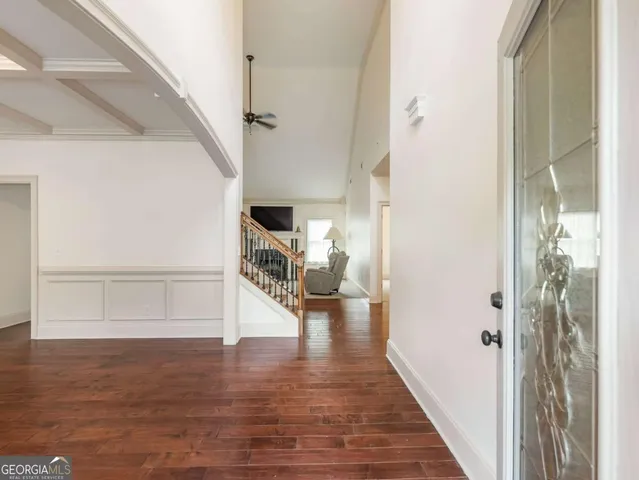a view of hallway with livingroom and wooden floor