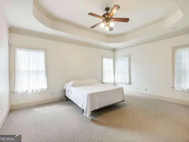 a spacious bedroom with a bed a window and closet