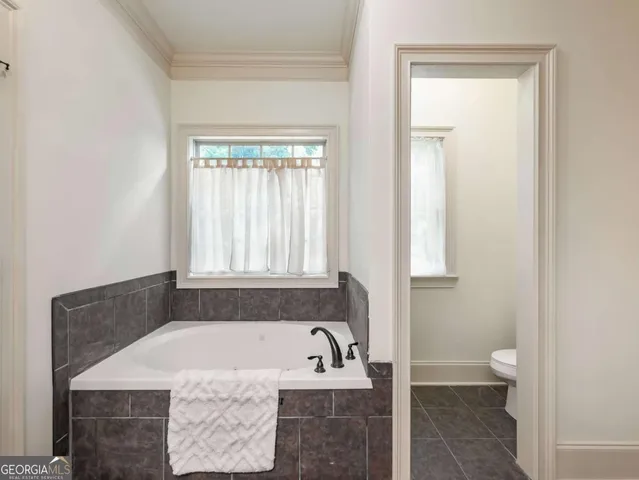 a bath tub sitting in a bathroom next to a window
