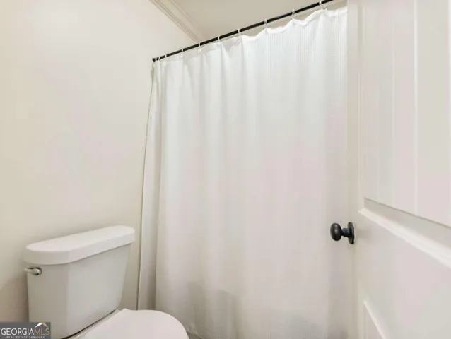 a white toilet sitting next to a shower