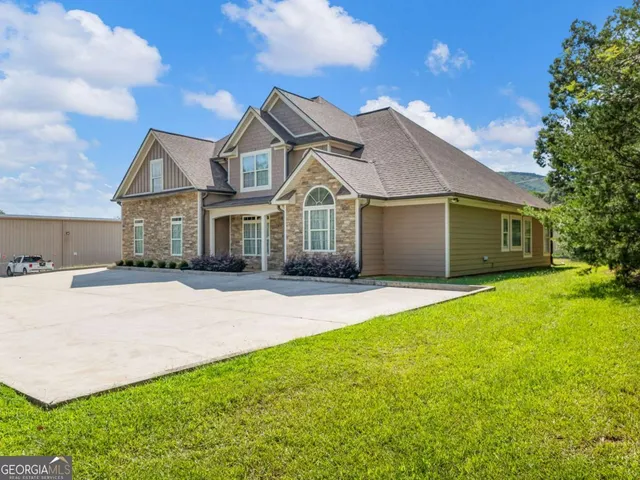 a front view of a house with a garden and yard