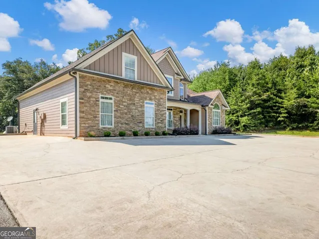 a front view of house with yard and trees in the background