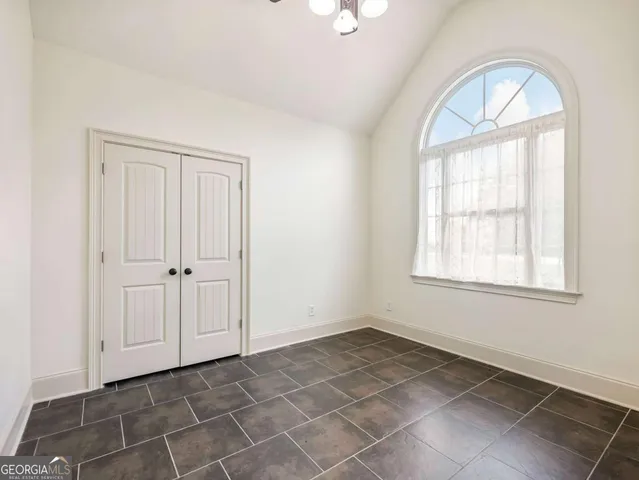 an empty room with windows and closet