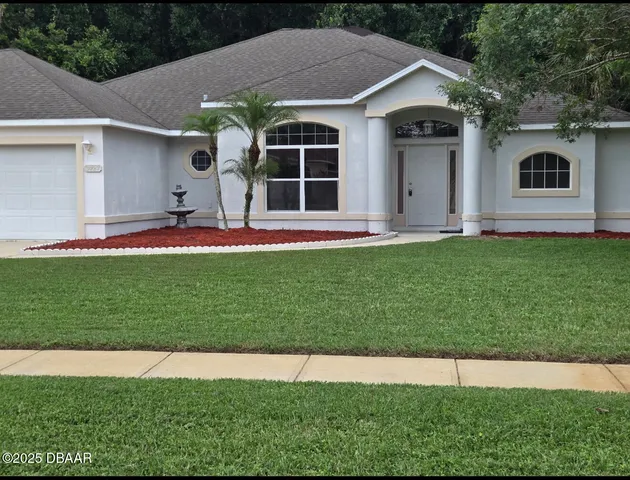a front view of a house with a yard and garage