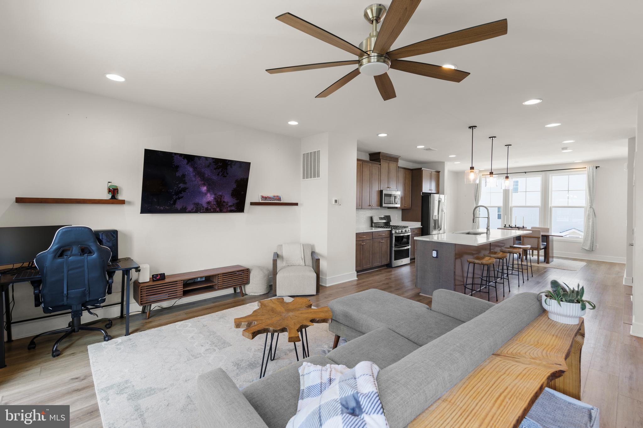 a living room with furniture kitchen view and a flat screen tv