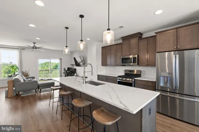 a kitchen with a center island a counter space a center island stainless steel appliances and cabinets
