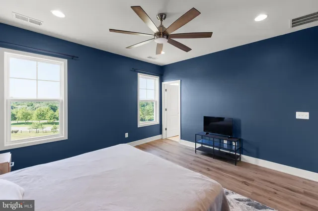 a bedroom with a bed window and a flat screen tv