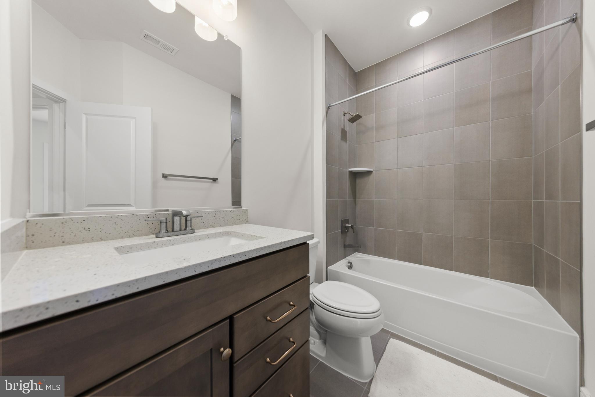 102 Phacelia Way Lake Front Royal, VA 22630 - Photo 26 of 29 a bathroom with a granite countertop sink a toilet and shower