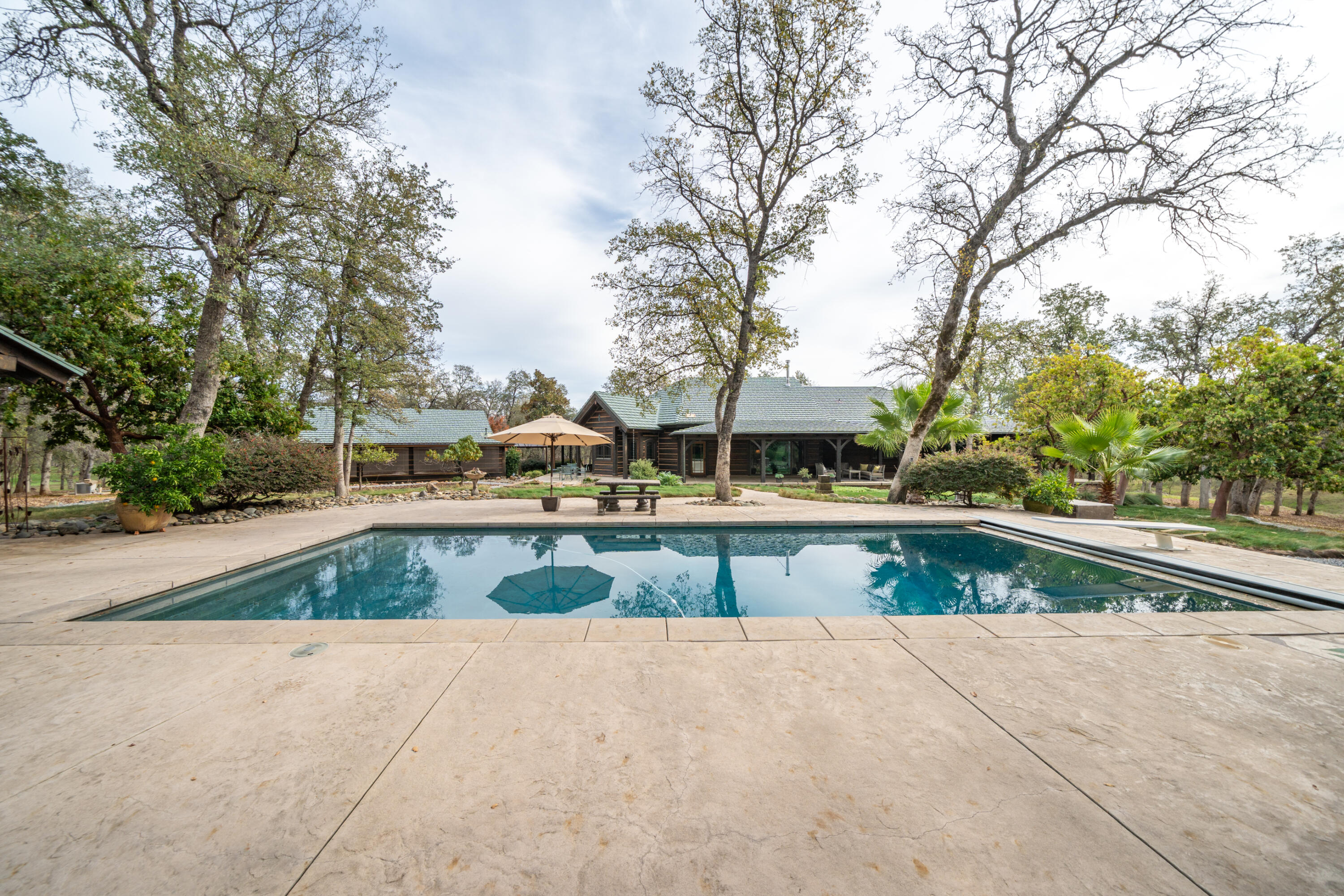 15900 El Camino Robles Road Redding, CA 96001 - Photo 84 of 117 a view of swimming pool with a yard and large trees