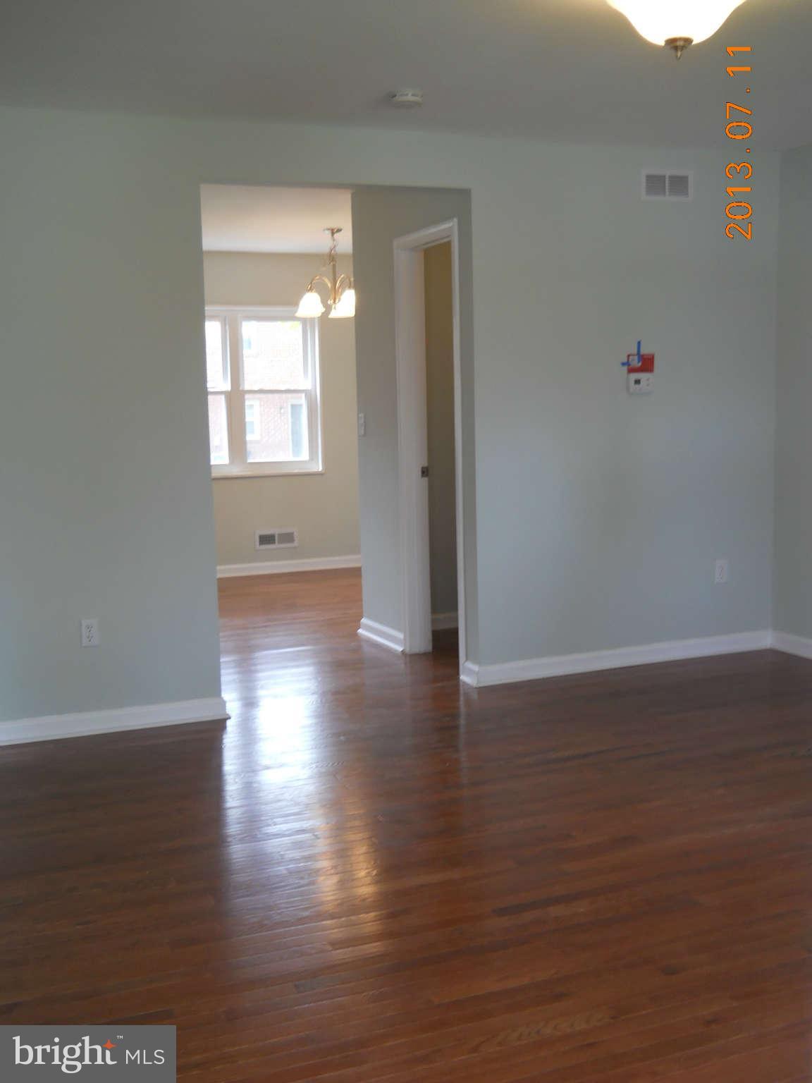 500 Queensgate Road Baltimore, MD 21229 - Photo 3 of 14 a view of an empty room with wooden floor and a window